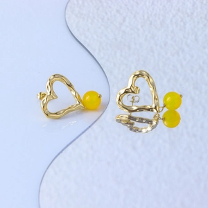Macro view of gold 18K plated stainless steel heart earrings with yellow beads