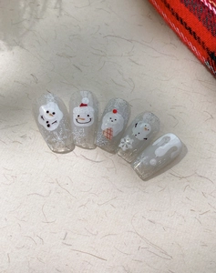 Macro view of 3D embossed snowman and white snowflake nail art stickers for winter