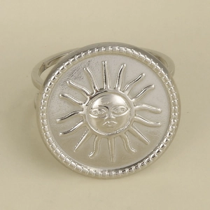 Detail of silver sun face relief ring with beaded edge and polished metallic surface