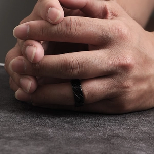 Detail of a men's black stainless steel ring with a chain link design on a model's hand