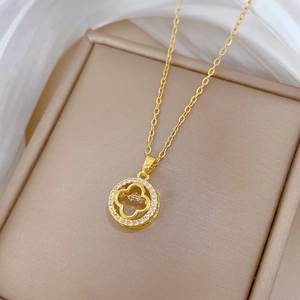 Detail of clover necklace with sparkling cubic zirconia set in a gold plated round pendant