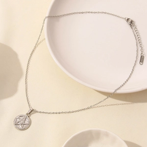 Dettaglio della collana in acciaio inox argento con ciondolo a stella e chiusura a moschettone