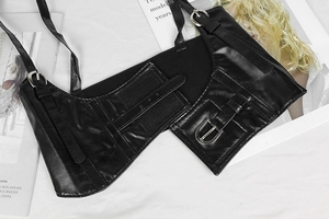 Detail of punk style black PU leather vest with functional pockets and silver metal buckles