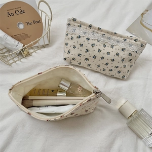 Detailed view of floral makeup bags with lace trim showing large storage capacity