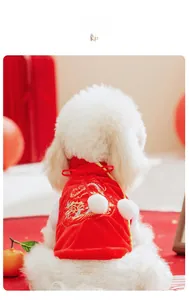 Détail d'un costume Tang rouge pour animaux avec broderie de dragon dorée et pompons