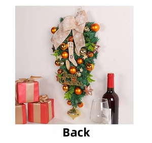 Christmas upside down tree swag with golden ornaments and Merry Christmas sign on white wall