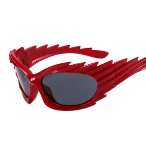 Futuristic red wing-shaped flame sunglasses with dark grey lenses for fashion runway