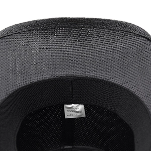Detail showing the inner woven straw texture, sweatband, and care label of the black hat