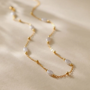 Elegante collana a catena dorata con perle ovali bianche e piccole perle dorate da donna