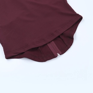 Macro shot of the burgundy yoga suit hem featuring a smooth zipper and detailed stitching