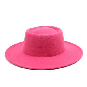 Close-up of bright pink wool felt hat texture with wide brim and flat top design