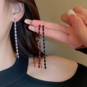 Primo piano di orecchini a nappa con zirconi marquise nei colori argento, rosso e nero