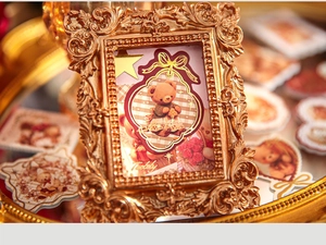 Close-up of vintage golden mini photo frame with ornate floral relief and teddy bear art