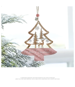 Close-up of pink wooden Christmas tree ornament with reindeer carving and metal bell
