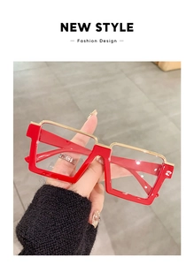 Detail view of red square oversized glasses with golden metal bridge and vintage style