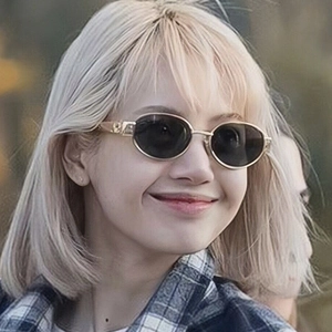 Close-up of retro oval sunglasses with black lenses and gold metal temple accents