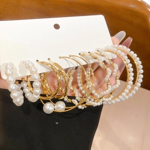 Detailed set of golden hoop earrings with pearls on display card featuring multiple styles