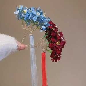 Detail of elegant fabric flower hairpins with long ribbons and golden fan base