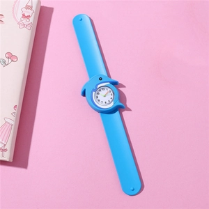 Close-up of blue dolphin-shaped silicone watch with cartoon quartz dial on pink background