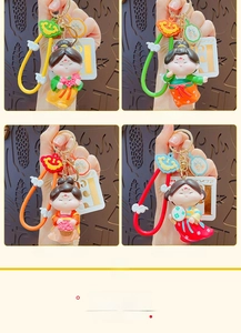 Detail of four colorful Tang Dynasty style cartoon doll keychains with decorative straps