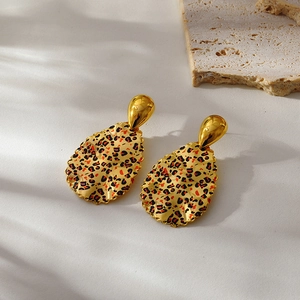 Macro detail of 18k gold plated teardrop earrings with red leopard print pattern