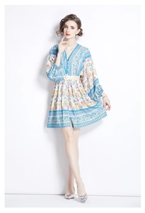 Detail of V-neck print dress with lantern sleeves and a white woven waist belt