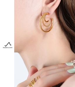 Detail showing 18K gold-plated stainless steel C-shaped double-hoop earrings and rings