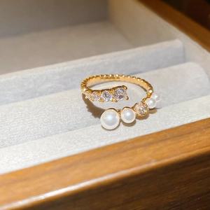 Detailed macro view of gold plated ring with elegant pearls and zircon in a velvet box