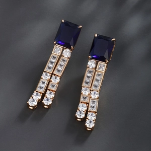 Macro view of geometric blue rectangular gemstone earrings with gold plated accents