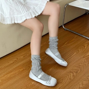 Calze a maglia grigie stile slouchy con ballerine in un ambiente domestico