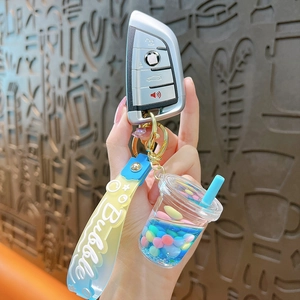 Handheld bubble tea keychain with blue liquid glitter and a matching silicone strap