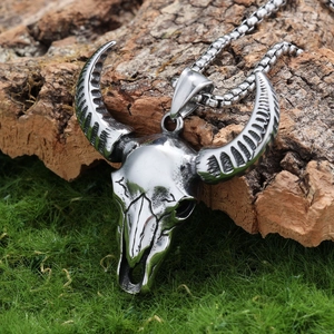 Gothic satanic ram skull pendant in silver finish placed on natural mossy tree bark
