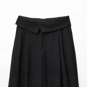 Women's black high-waisted trousers featuring an asymmetric folded waist and raw hem details