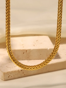 Dettaglio macro della collana a catena intrecciata dorata con finitura in oro 18K