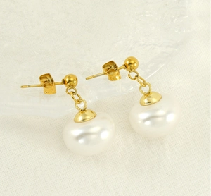 Détail de boucles d'oreilles dorées style français vintage avec perles élégantes