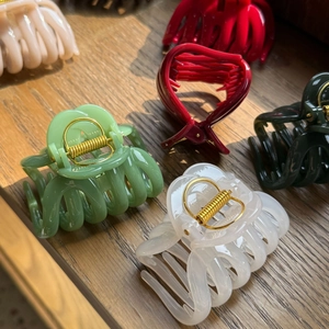 Close-up of elegant pumpkin-shaped hair claws in multiple colors on a wooden surface
