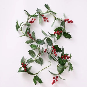 Artificial Christmas garland with green holly leaves and red berries on a white background