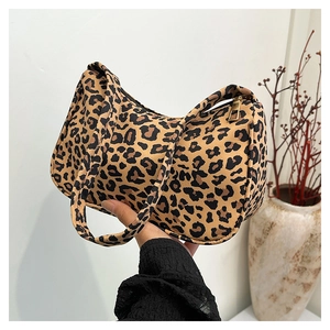 Detailed close-up of leopard print underarm bag with gold metal zipper and canvas texture