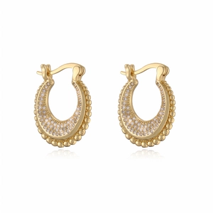 Close-up of vintage hollow gold earrings with pave zircon and micro-bead edges