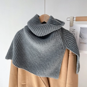 Detail of grey knitted turtleneck scarf featuring vertical rib texture on khaki coat