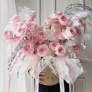 Pink rose and white orchid floral gift basket with feathers and sequin stems