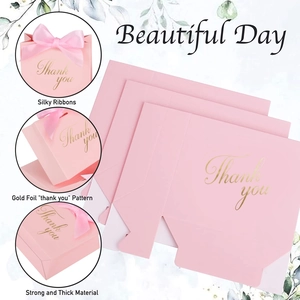 Détail boîte cadeau mariage rose avec texte doré Thank You et ruban en soie