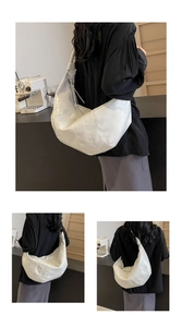 Detail of white large croissant bag showing quilted stitching and shiny PU leather finish