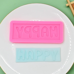 Pink silicone HAPPY letter mold for DIY fondant cakes and clay crafts on a ceramic plate