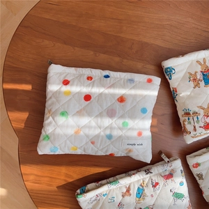 Flat lay of quilted cotton cosmetic bags with animal prints on a wooden table