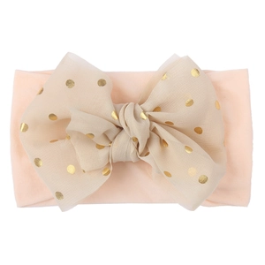 Detail of pink nylon headband with a beige lace bow featuring gold polka dots for babies