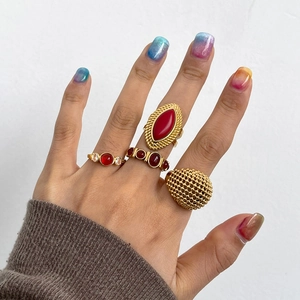 Set of vintage gold stainless steel rings with red agate stones on female model hand