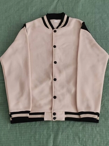 Close-up of pink and black baseball jacket with striped ribbed cuffs and metal snap buttons