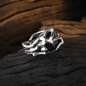 Retro multi-layer silver ring with large black zircon stone on textured wood surface