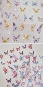 Macro shot of laser butterfly nail art stickers with iridescent stars and golden accents